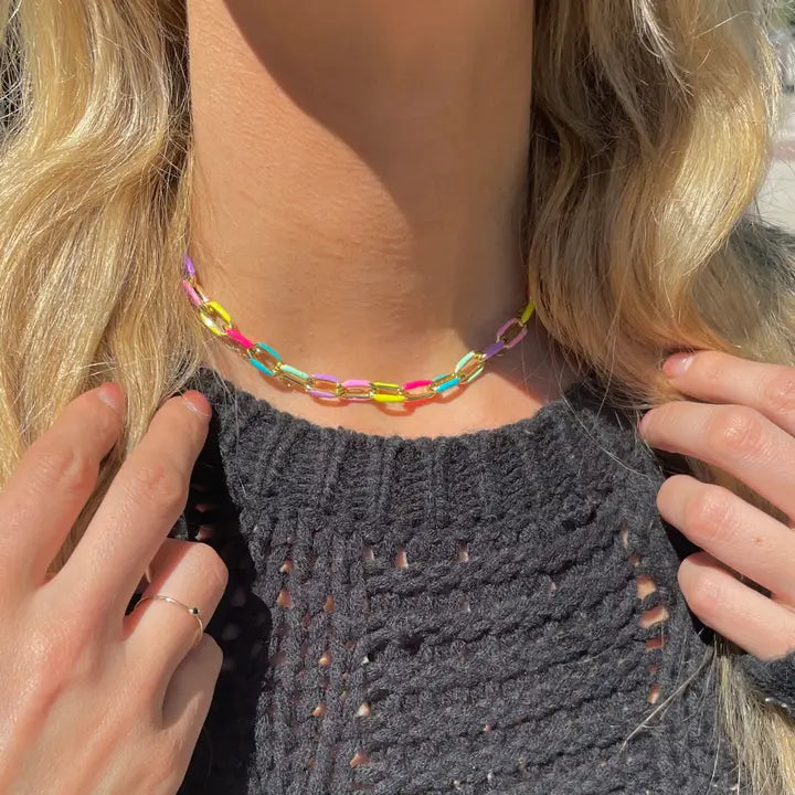 Pippa multicolor paperclip chain necklace worn close to the neck above a dark gray knit top.