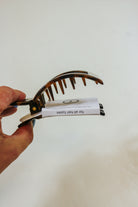 TELETIES Medium Tortoise Square Clip held in hand, side view of the teeth