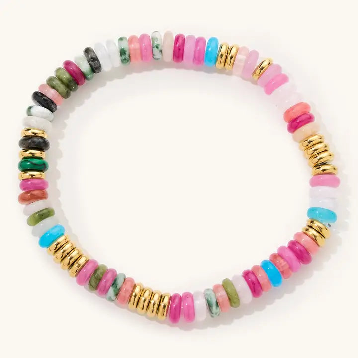 Julia multicolor beaded stretch bracelet with pink, blue, green and pale beads and gold accents on a light background.