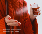 Touchland Cranberry Fizz Power Mist being sprayed onto a hand, red sweater background