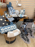 2 Fly Co cactus pillow in blue on a store display with Rodeo pillow