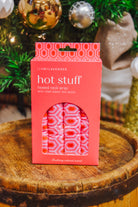 Lemon Lavender Hot Stuff Heated Neck Wrap in hot pink geometric print, boxed by a Christmas tree