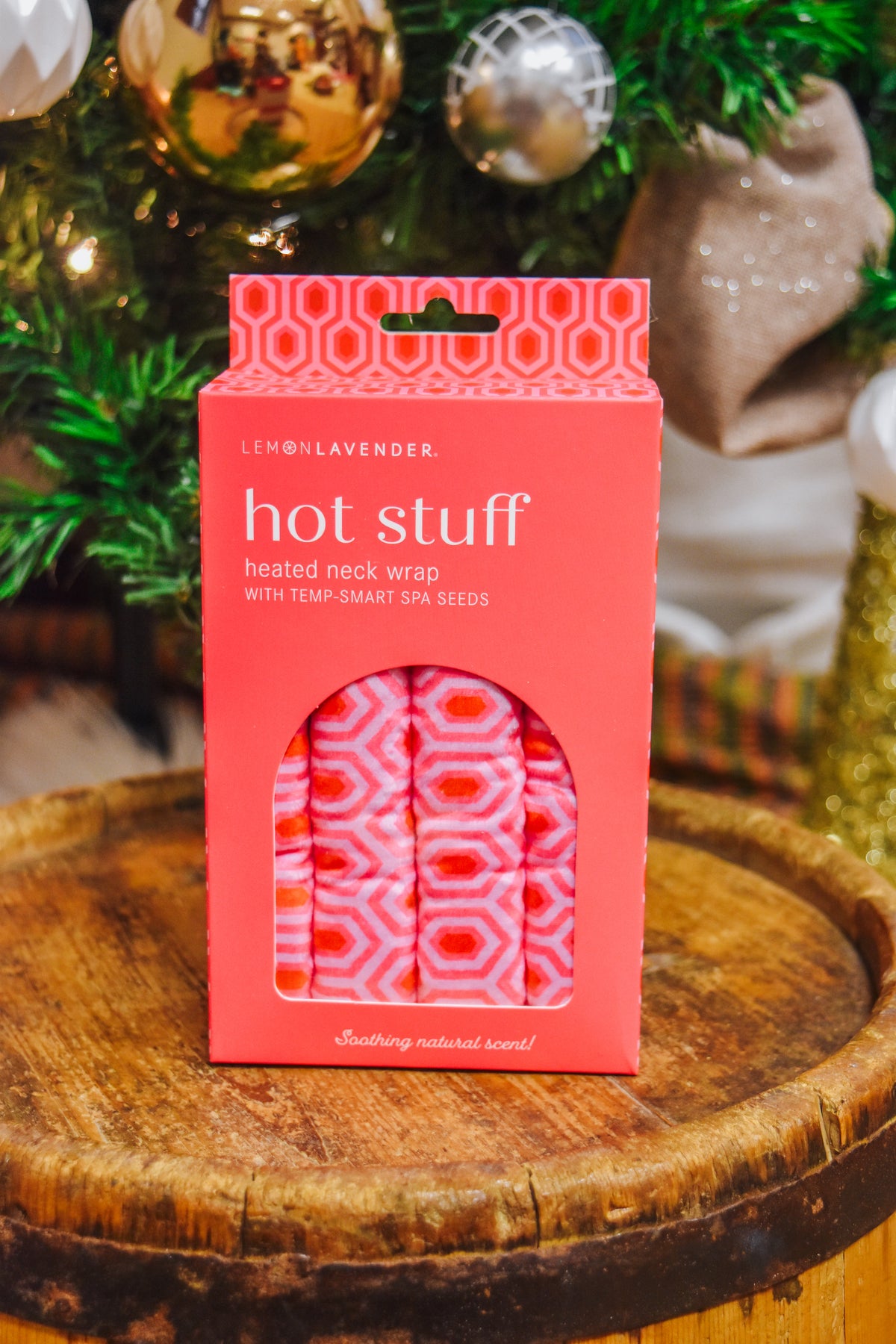 Lemon Lavender Hot Stuff Heated Neck Wrap in hot pink geometric print, boxed by a Christmas tree