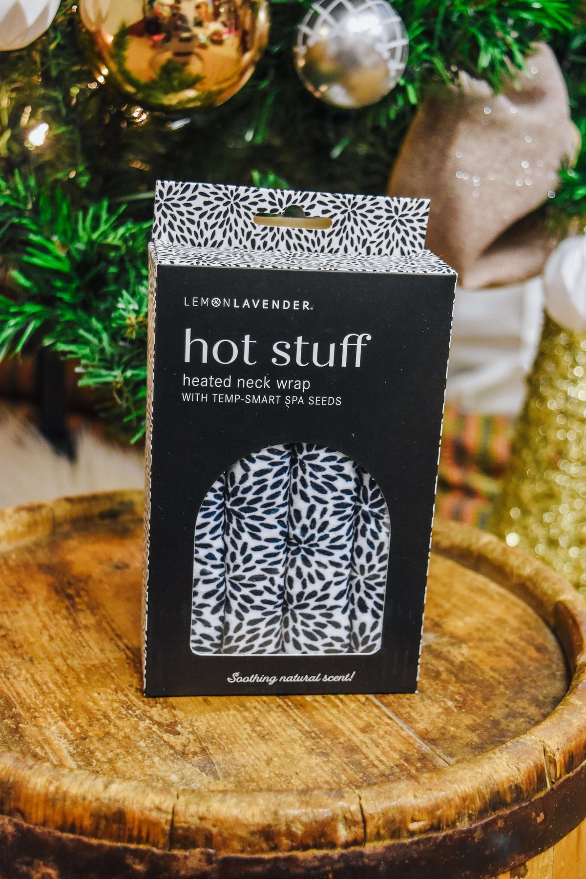 Lemon Lavender Hot Stuff Heated Neck Wrap in black and white print, boxed by a Christmas tree
