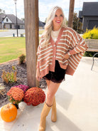 Oversized Camel Multi striped cardigan with a button front, styled with a black lace-trim skirt and tan boots.