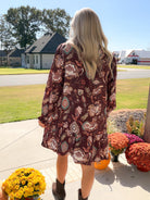 Back view of merlot floral long sleeve dress showing allover print and gathered ruffle hem