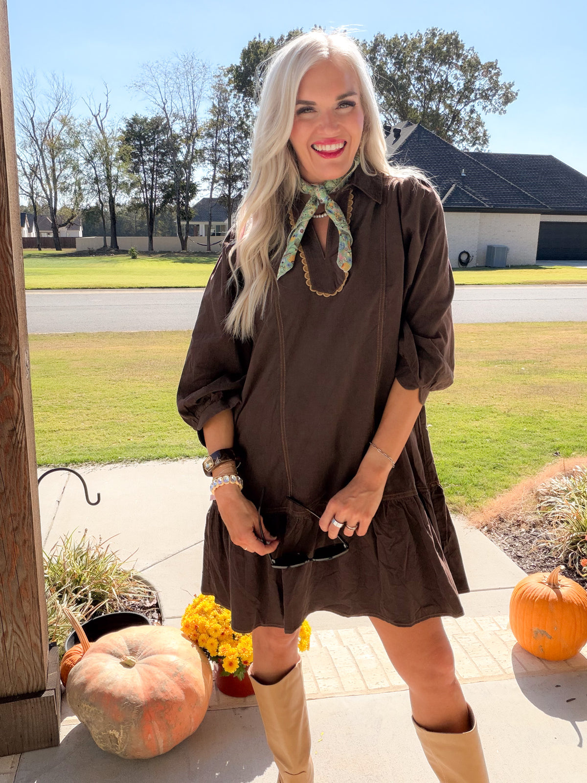 Front view of brown corduroy dress showing collared split neckline, banded puff sleeves, and ruffle hem