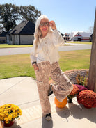 Full outfit with a natural button-front short shacket, printed wide-leg pants, and black high-top sneakers.