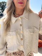 Close-up of the natural shacket's waffle-textured panels, chest pockets, round buttons, and raw-edge seams.