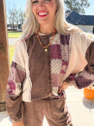 Close-up of chocolate mineral-washed sweatshirt with paisley patchwork, cream panels, and exposed seams