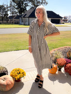 Model wearing the Side Notes gingham midi dress, showing the shirt collar and easy silhouette from an angled front view.