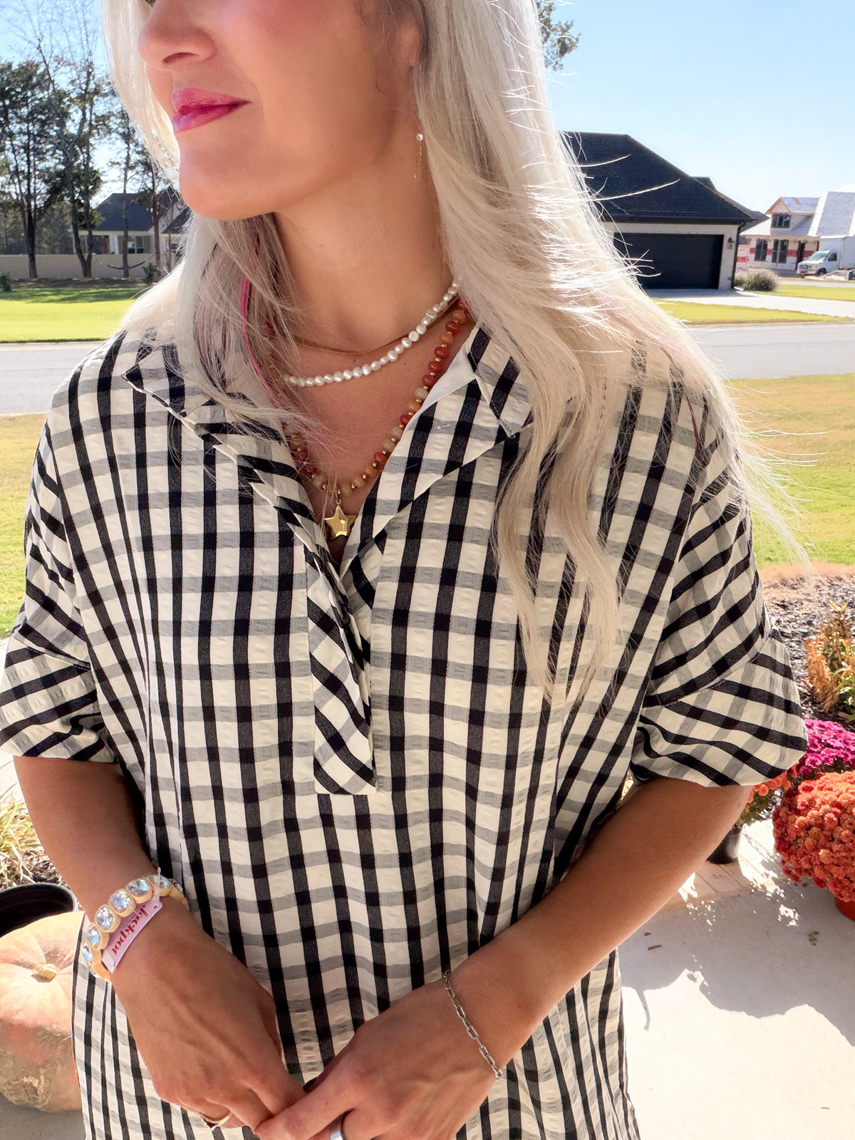 Close-up of the gingham midi dress showing its shirt collar, partial button placket, and short sleeves.
