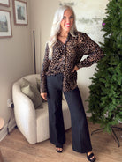 Front view of Dear John Lolita leopard blouse showing its relaxed shape and long sleeves, styled with black pants.