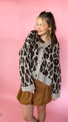 Leopard print sweater cardigan with button-down front and long sleeves worn by a model.