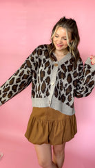 Leopard print sweater cardigan with button-down front and long sleeves worn by a model.