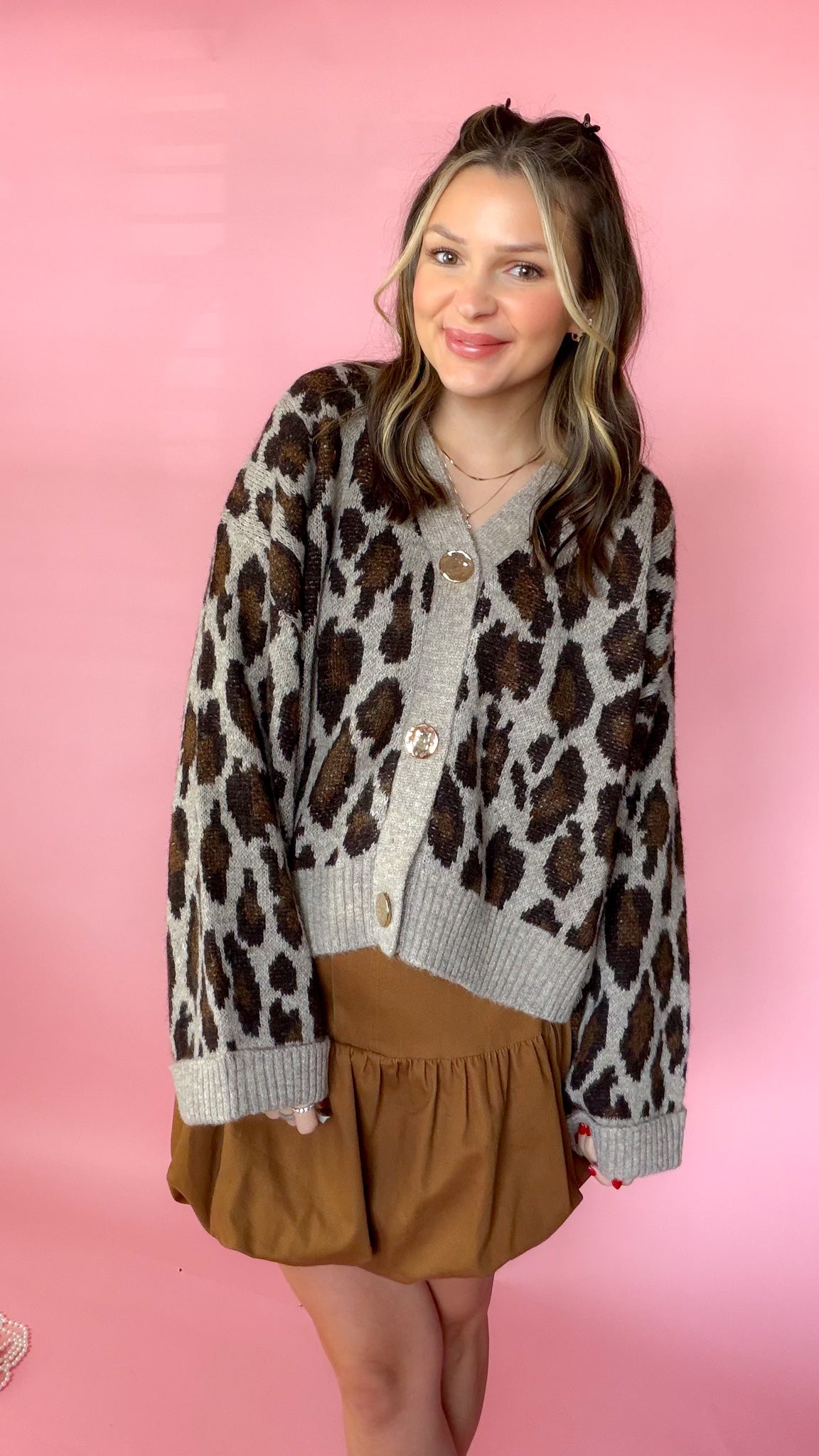 Leopard print sweater cardigan with button-down front and long sleeves worn by a model.