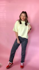 woman standing against pink background showcasing the women's silver leopard jeans