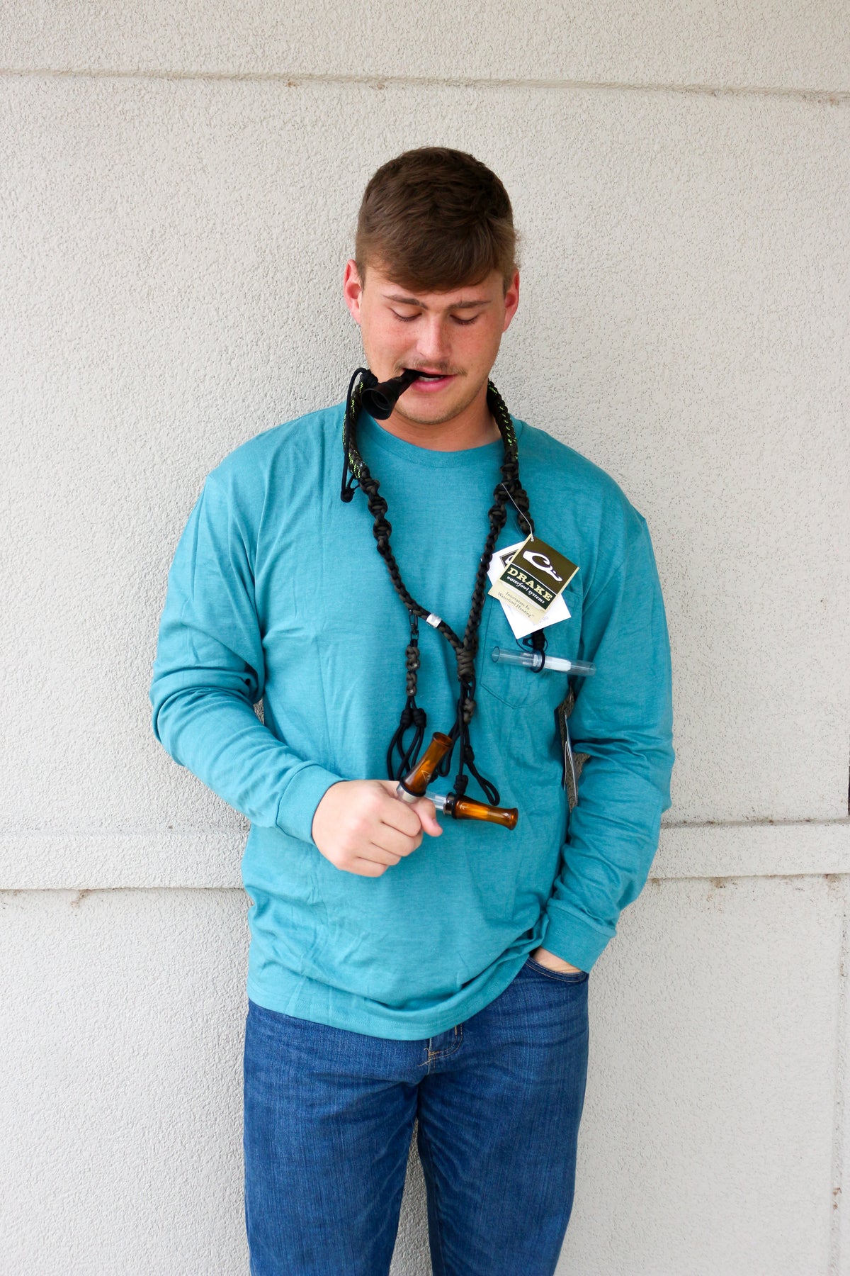 Drake Paracord Black and Olive Duck Caller's Lanyard worn by a man blowing a duck call