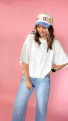 woman picturing short sleeve button up top against a pink background