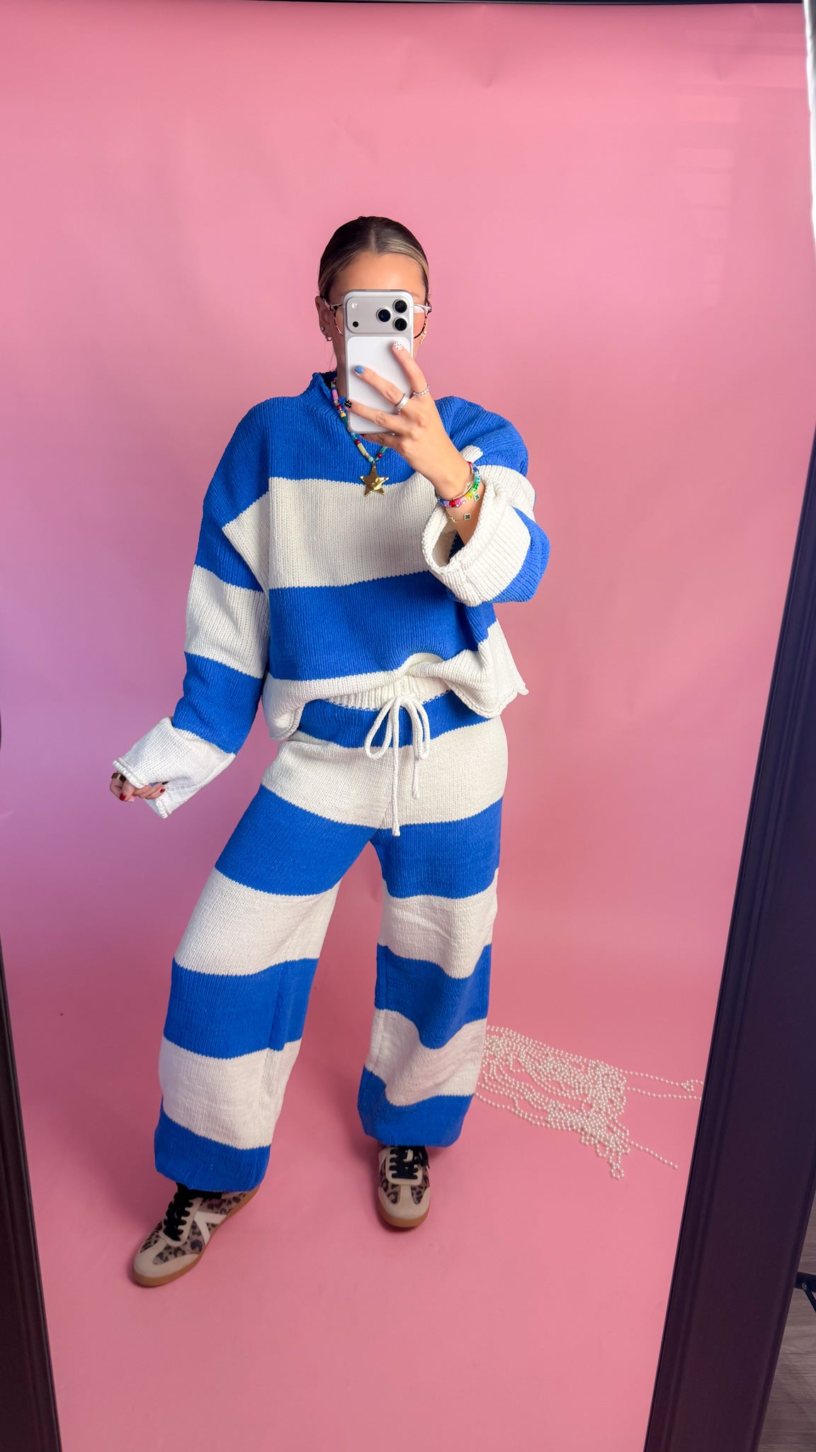 woman wearing blue stripe knit sweater against pink background