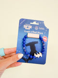 Fahlo Voyage Hammerhead Shark Tracking Bracelet in blue beads with shark charm, on its card