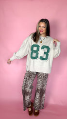 Keeping Score oatmeal 83 sweatshirt worn oversized with zebra pants, full-length front view