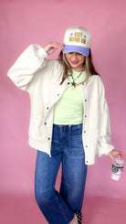 Covered In Goods ecru shacket worn open over a green tee with wide leg jeans