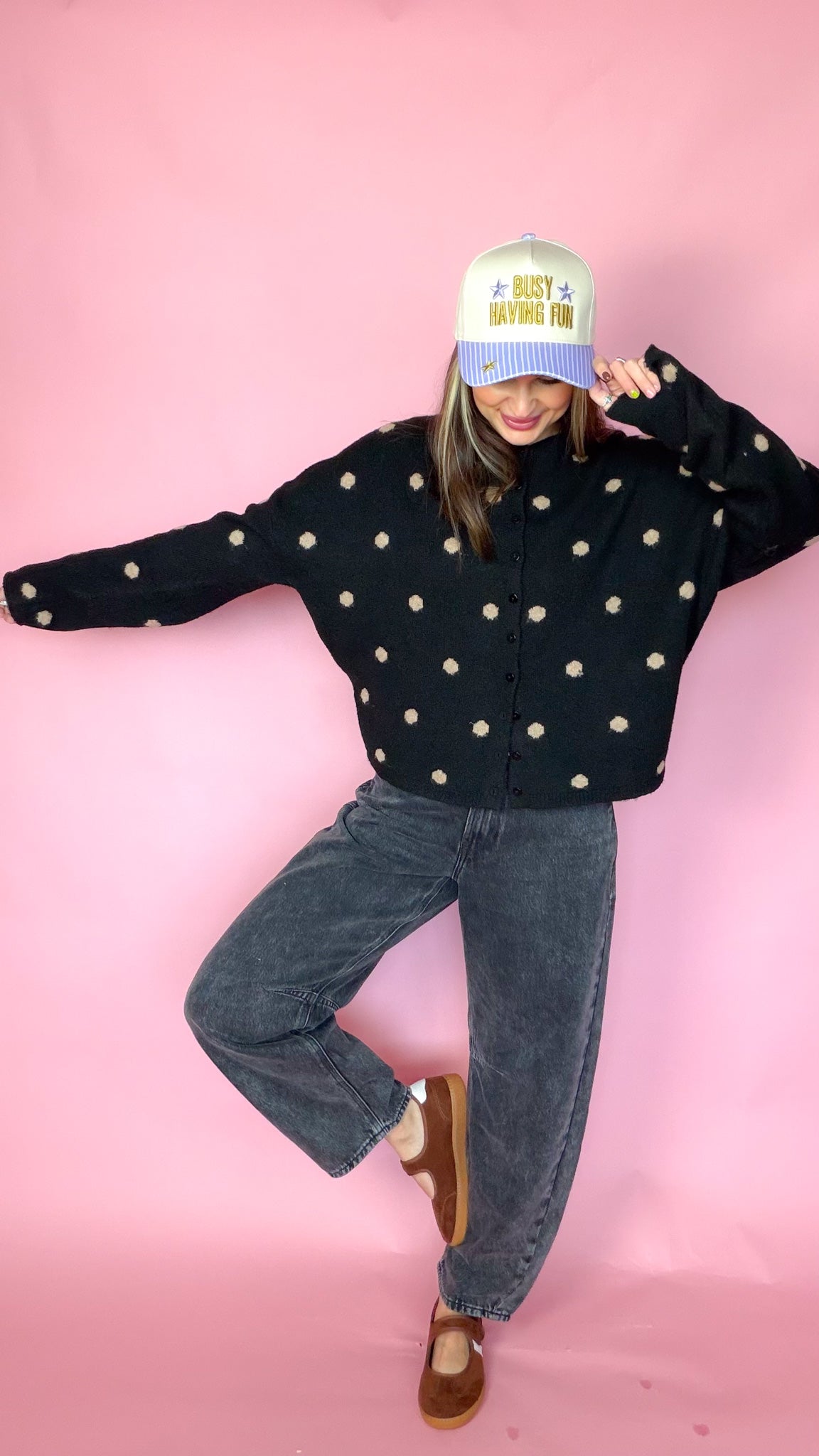 At A Glance black polka dot sweater, arms out to show the sleeves and boxy fit