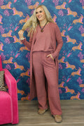 Woman wearing a beige outfit with a long cardigan against a white background