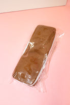 Jumbo ice cream sandwich squishy with brown cookie-style layers and a white center, wrapped on a pink surface.