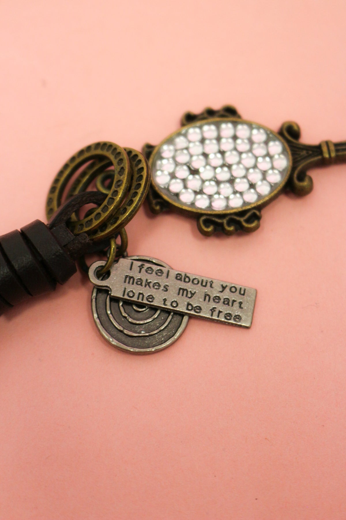 Close-up of To Be Free Western Keychain Charm showing clear sparkling stones, rainbow accent and engraved message charm
