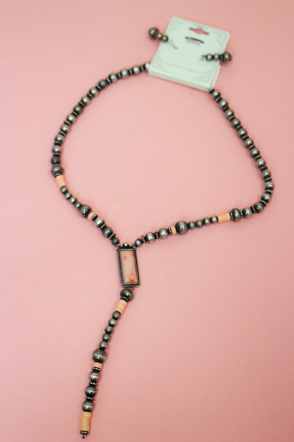 Silver-tone and pink beaded necklace with a rectangular centerpiece and long Y-shaped drop, shown with matching earrings.