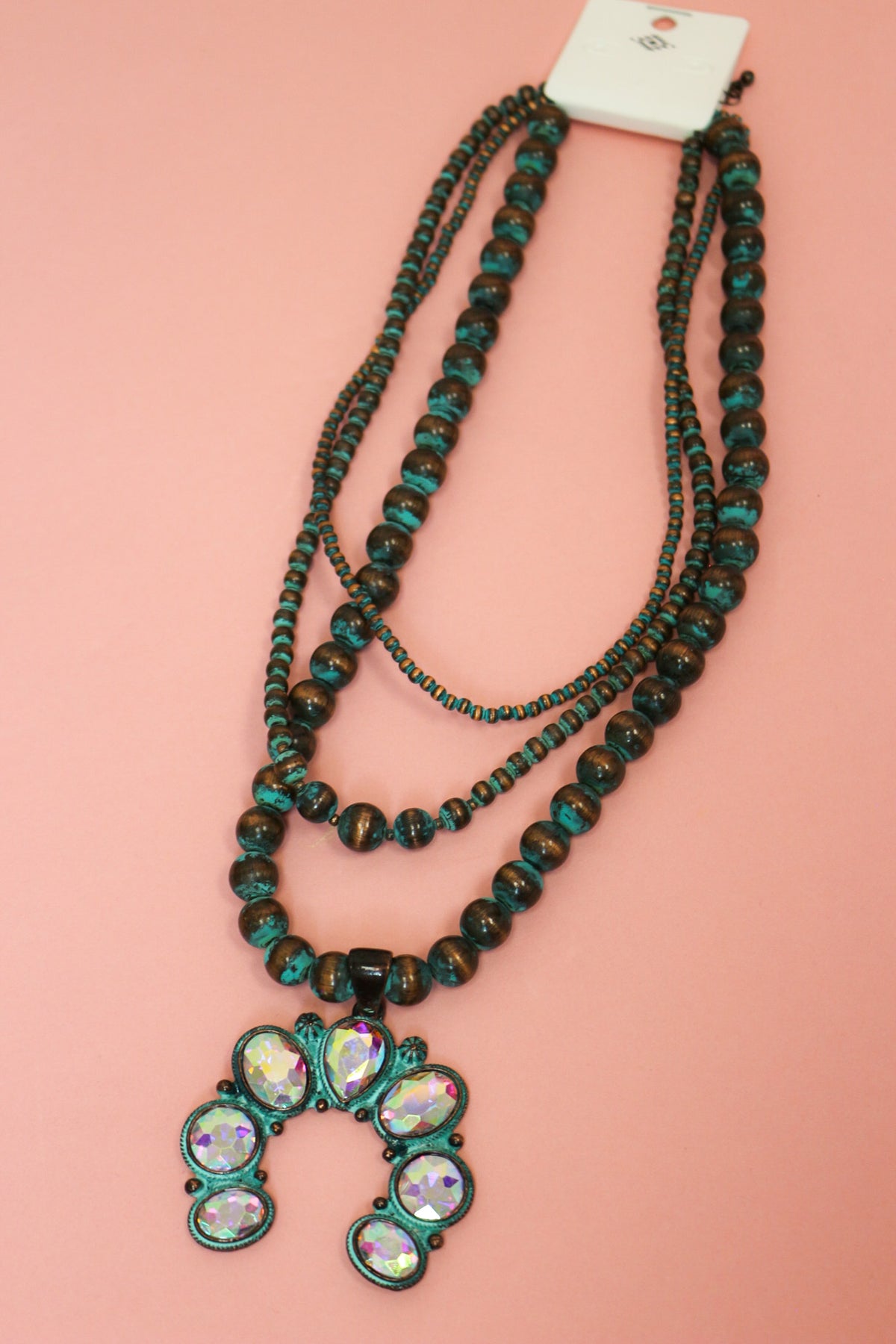 Three-strand chunky Western necklace with dark brown and turquoise-colored beads and an iridescent crescent pendant.