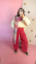 Brick red polka dot barrel jeans with cream sweater and plaid scarf, mirror selfie