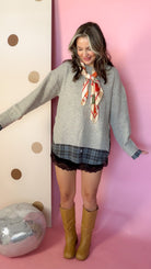 A Warming Welcome sweater, model with arms out and boots