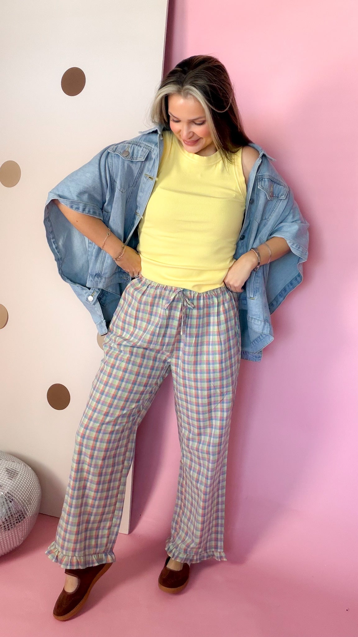 Women's Daisy yellow ribbed knit tank top styled with an open denim shirt and plaid pants, model looking down.