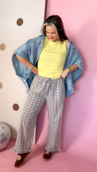 Women's Daisy yellow ribbed knit tank top styled with an open denim shirt and plaid pants, model looking down.