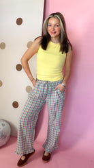 Front view of women's Daisy yellow ribbed knit tank top worn with plaid pants, without an outer layer.