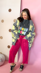Red mineral wash barrel pants styled with a graphic tee, gray star cardigan and printed sneakers.