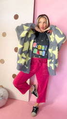 Red mineral wash barrel pants on a model with one knee raised, showing the roomy baggy leg shape.