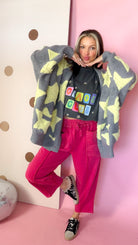 Front view of Red drawstring barrel pants worn with a graphic tee, star cardigan and printed sneakers.