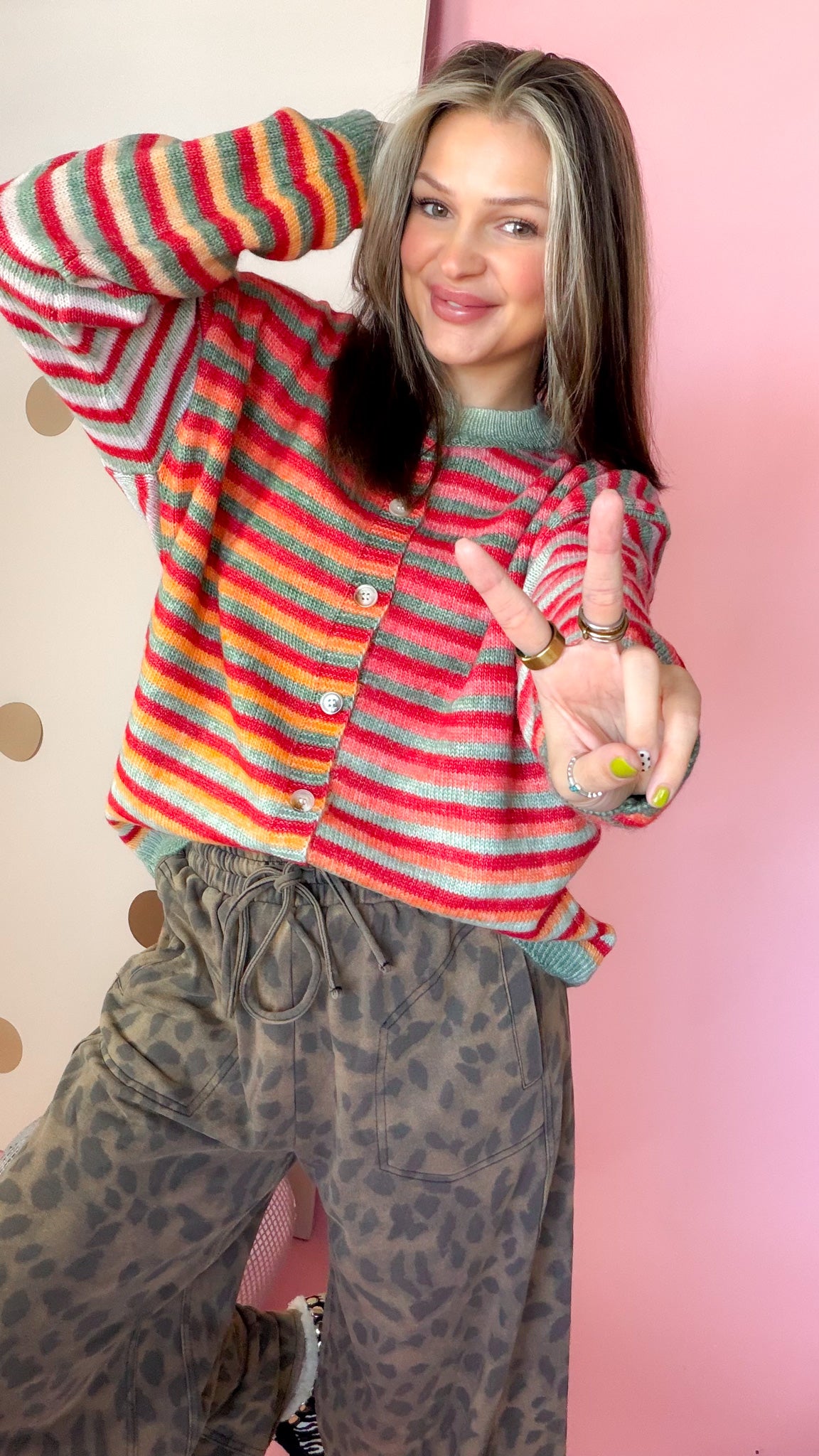 Close front view of women's Christmas striped cardigan showing multicolor space-dye knit and button front