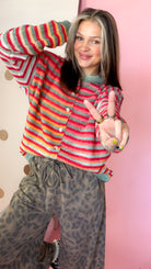 Close front view of women's Christmas striped cardigan showing multicolor space-dye knit and button front