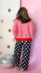 Back view of red and ivory striped sweater showing horizontal stripes, drop shoulders, and solid red hem.