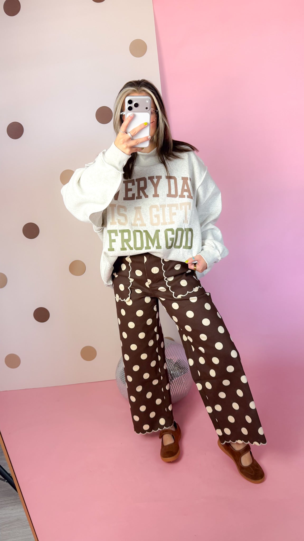 Full-length mirror view of brown polka dot wide leg pants with a cream sweatshirt and brown flats.