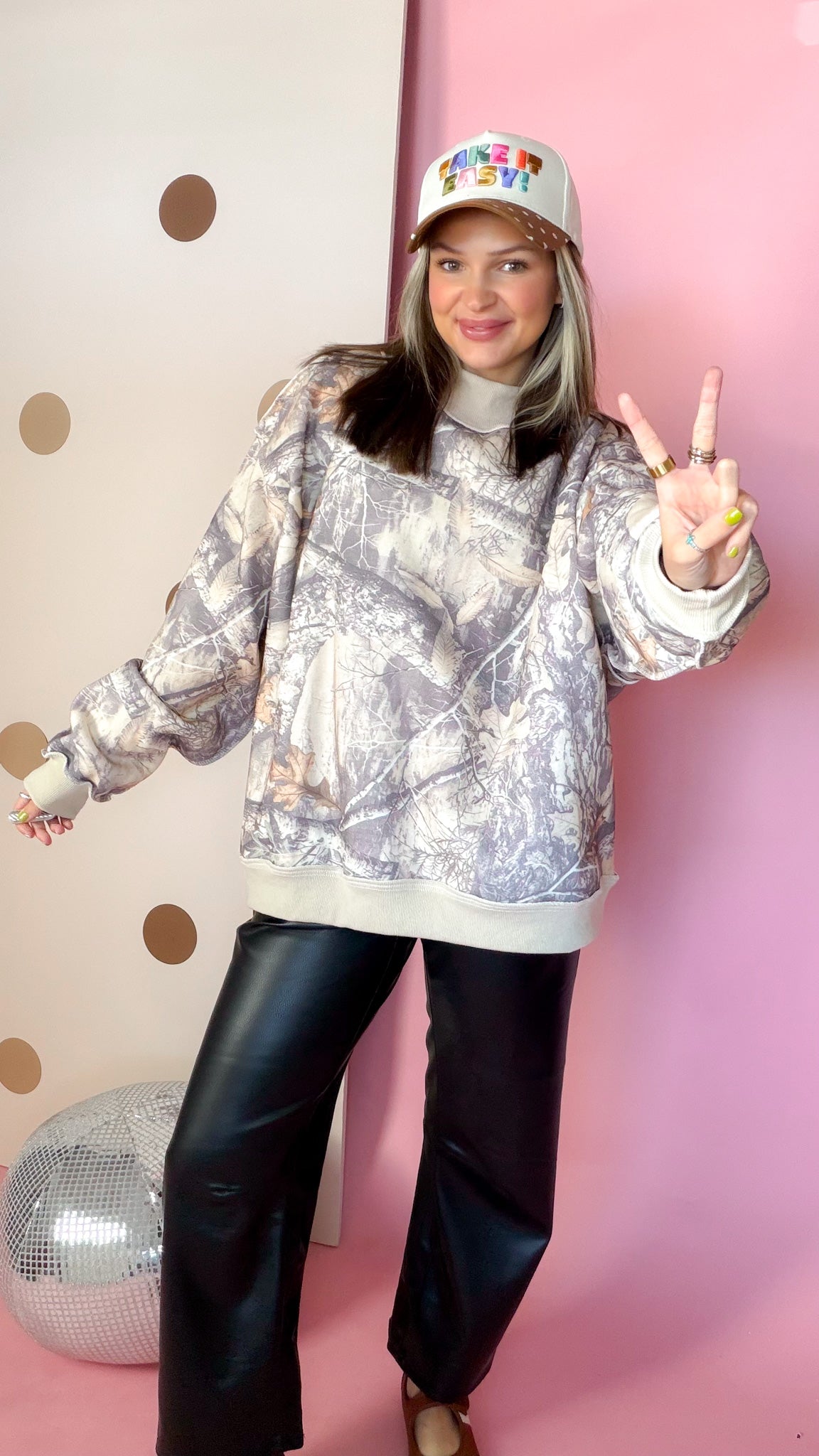 Women's Real Tree camo sweatshirt with long sleeves and taupe trim, modeled with one arm extended.