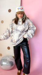 Taupe camo mock neck sweatshirt styled with black wide-leg pants and brown flats.