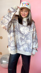 Close front view of taupe Real Tree camo sweatshirt showing mock neck, long sleeves, and light trim.