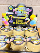 Close-up of Mystery Dim Sum Surprise squishy display with round yellow containers and Glows in the Dark signage.
