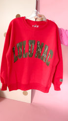Front of red Lulu Mac crewneck sweatshirt with large arched Bottomland camo lettering, ribbed trim, and sleeve logo patch.